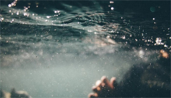 How do you clean sludge from a swimming pool?